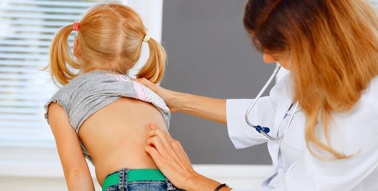 doctor examining a child's back for lower back pain